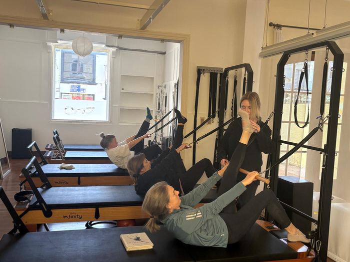 Instructora acompañando a las alumnas durante la clase de Pilates en Pocitos