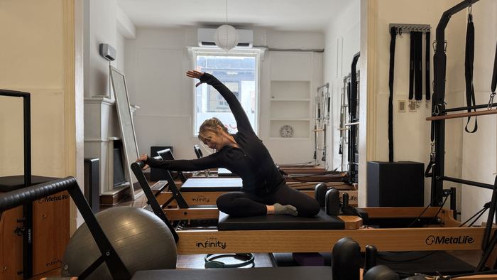 Elongación lateral sobre el Reformer en el Estudio Uno Pilates