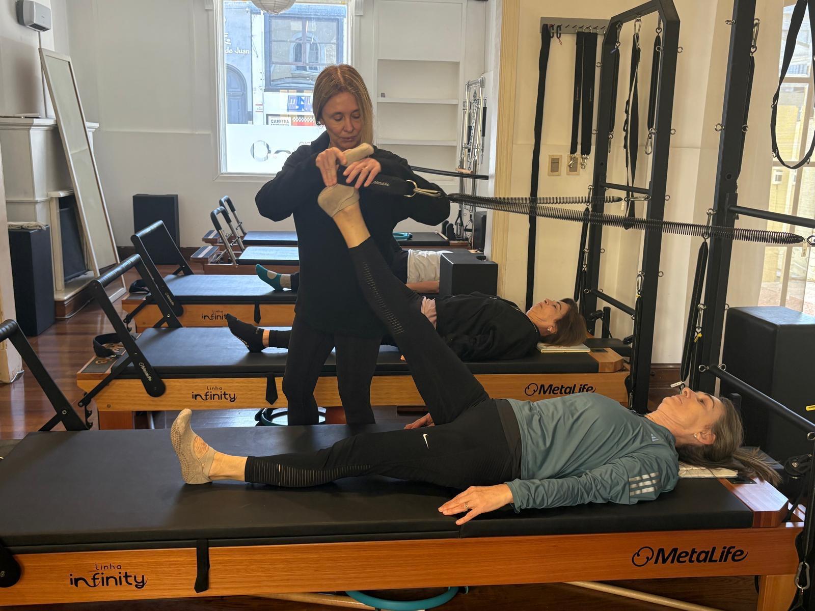 Instructora acompañando un ejercicio con la Torre integrada al Reformer